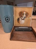 Group view of vase, framed portrait, hole punch, wood tray
