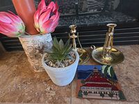 Group shot showing brass candlesticks, ceramic tile, planter with succulent, birch bark vase with faux flowers