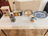 All six decorative ceramic pieces and wooden spice chest arranged on table