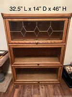 Front view of oak barrister bookcase showing three glass drop-front sections and dimensions