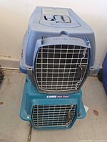 Blue carrier stacked over teal carrier showing front wire doors