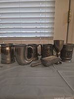 All seven pewter items grouped on tabletop