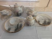 Full tea set laid out on table showing main pieces and plates
