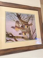 Framed bird print showing three birds flying among bare branches