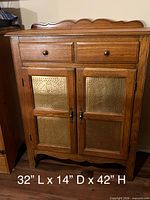 Full frontal view of cabinet showing drawers, doors, decorative metal panels