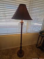 Full view of floor lamp standing by window