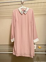 Pink collared dress on hanger