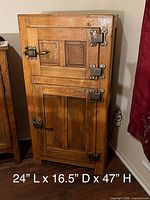 Front view closed showing oak-tone wood, two doors, metal hardware, size overlay