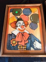 Framed clown print with balloons in wood frame