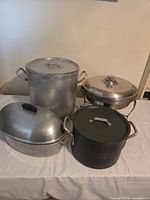 overview of four cookware pieces with lids and stand