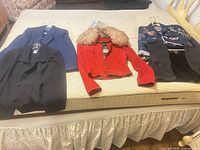 Four jackets and pair of boots laid out on mattress