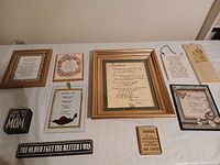 Overview of twelve framed prints and plaques laid on table