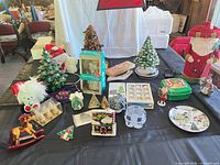 Table view of entire assortment including ceramic trees, plush figures, boxed GE angel topper and various ornaments