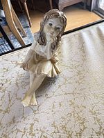 Painted ceramic seated girl figurine