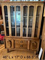 Full view of china cabinet showing glass doors, drawers, side doors, legs