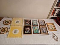 All ten framed artworks laid out on table