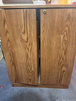Front view of closed oak laminate cabinet showing two doors and lock