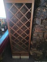 Front view of tall oak wine rack showing full lattice interior and drawer