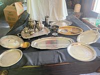 Group shot of all silver-plated tea set pieces, trays and bowls on table