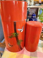 front view of both canisters showing painted design and relative sizes