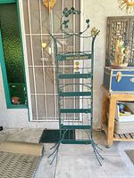 Full view of green Perrier-Jouët metal wine rack showing five tiers and overall height