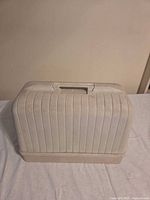 Closed plastic carrying case showing ribbed texture and handle