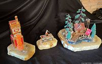 All three sculptures grouped: slot machine, handcar, cabin scene