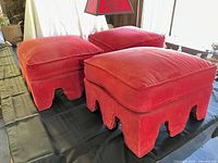 All three red velvet skirted ottomans