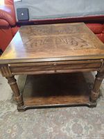 Full view of oak veneer coffee table showing top parquet pattern, drawer front, turned legs, and lower shelf