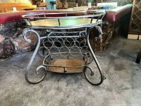 full view of metal bar cart showing both tiers, scroll legs and wine rack