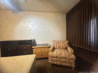 Room overview showing dresser, nightstand and armchair