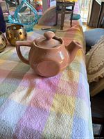 Side view of pink ceramic teapot with lid