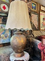 Full view of lamp with pleated shade on side table