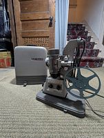 Projector with reel and carrying case displayed together