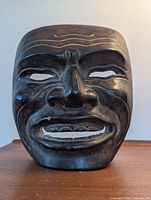 Front view of carved wooden smiling mask