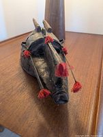 Oblique view showing overall mask form, horns and tassels