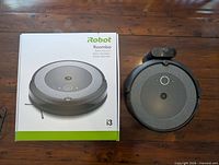 Roomba i3 vacuum beside original box