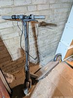 Full view of Ninebot KickScooter MAX standing against wall