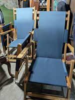 Two wooden frame patio chairs with blue sling fabric