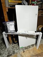 White 55" desktop panels, white metal legs and frame parts, hardware and manual visible