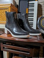 Side view of both boots showing overall condition, color, heel style