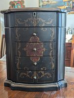Front view closed showing four drawers, decorative motif, keyhole