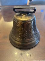 Side view of Swiss brass bell showing top loop and decorative floral casting