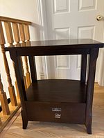 Front view highlighting drawer, shelf, and legs