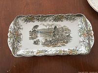 Rectangular platter showing scenic transferware pattern, floral border and gold trim