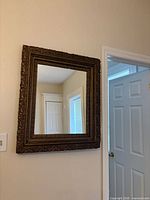 Front view of mirror showing ornate gilded frame and reflective glass