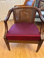 Front view highlighting cane back, wood frame and burgundy seat cushion
