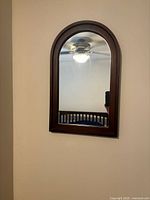 Front view of arched walnut framed mirror