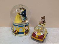 Both Beauty and the Beast snow globes side by side