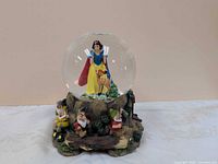 Front view of snow globe showing Snow White, Bambi, three dwarfs on base